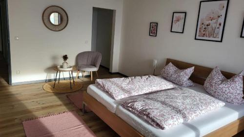 a bedroom with a bed and a table and a chair at Ferienwohnung Gipfelblick in Freyung