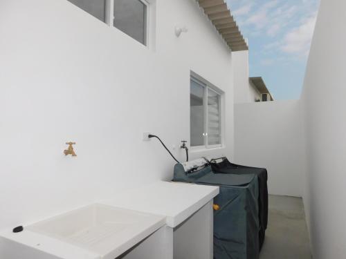 a white kitchen with a sink and a window at Casa Florencia gran piscina in Salinas