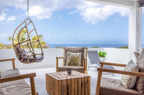 a living room with a chair and a table at The Reef - Blue Bay Golf & Beach Resort in Willemstad