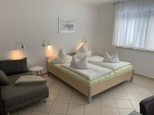 1 dormitorio con cama con almohadas y sofá en Ferienwohnungen Börnert, en Tellerhäuser