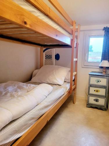 une chambre avec deux lits superposés et une fenêtre dans l'établissement Gîte VILLA Nautica Résidence Cap Soleil, à Vendres
