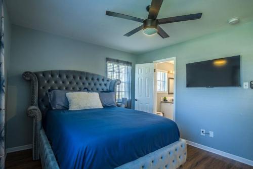 Schlafzimmer mit einem blauen Bett und einem Deckenventilator in der Unterkunft Chic Living in Houston: Stylish 2 Bedroom, 2 Bath in Houston