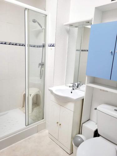 une salle de bain blanche avec une douche et un lavabo dans l'établissement Gîte VILLA Nautica Résidence Cap Soleil, à Vendres