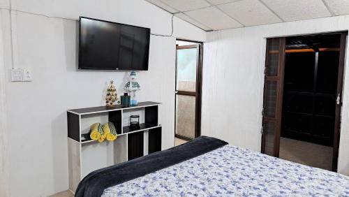 1 dormitorio con 1 cama y TV de pantalla plana en Villas El Amatle, 
