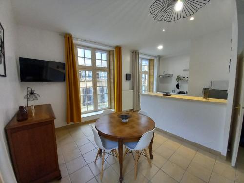 Il comprend un salon avec une table en bois et une cuisine. dans l'établissement le Fort de Bayle, à Sedan