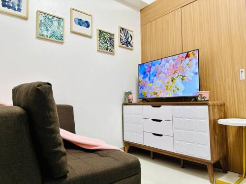 a living room with a television on a dresser at Makati Staycation by Marco - SMDC Lush in Manila