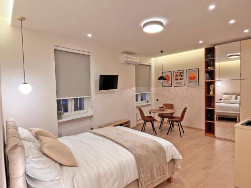 1 dormitorio con 1 cama, mesa y sillas en Terazije Center Apartments, en Belgrado