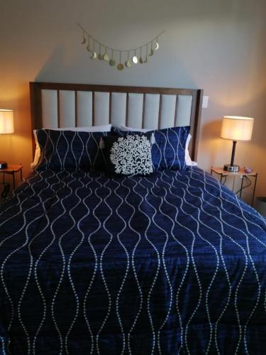 a bedroom with a bed with a blue comforter and two lamps at Residencial en San Miguel de Allende in San Miguel de Allende
