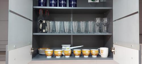 a cupboard filled with lots of glasses and plates at Apartman Panorama in Požarevac