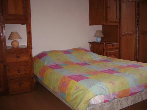 a bedroom with a bed with a colorful comforter at LES HIRONDELLES in Les Orres