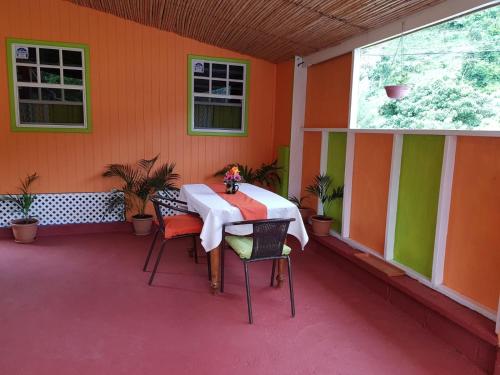 a patio with a table and chairs in a house at Salz Cozy Inn in Roseau
