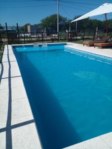 a large blue swimming pool with an umbrella at La Delia in Gualeguaychú