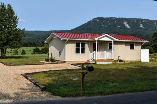 ein kleines Haus mit rotem Dach im Gras in der Unterkunft Holly Tree Retreat Located In Beautiful Luray, VA. in Luray