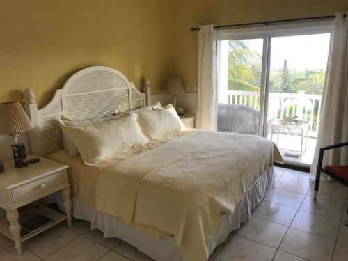 1 dormitorio con 1 cama blanca grande y balcón en The Sanctuary Condominium Playa Azul 6, en Playa Azul