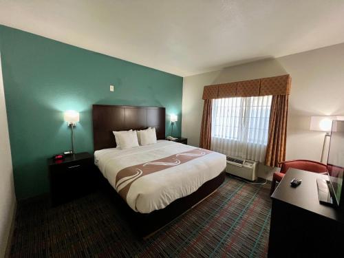 ein Hotelzimmer mit einem großen Bett und einem Schreibtisch in der Unterkunft Quality Inn & Suites Near University in Waco