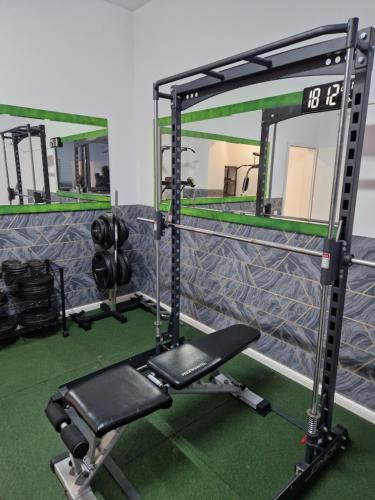 a gym with a mirror and a bench at Global Residence Lake View in Bucharest