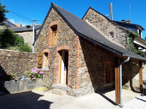 - un petit bâtiment en briques avec une fenêtre et des fleurs dans l'établissement Location Maison 4 / 8 personnes en Côtes D'Armor, à Étables