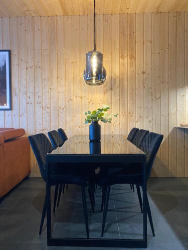 a dining room table with chairs and a potted plant at RzepiskaView in Rzepiska