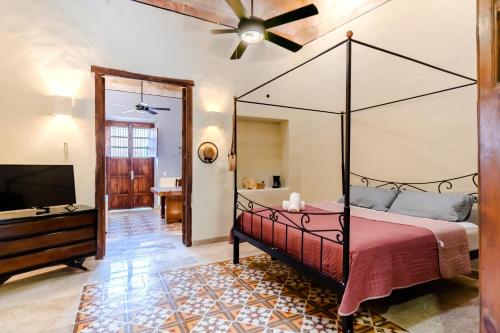 a bedroom with a canopy bed and a flat screen tv at Meriblau Hotel Boutique in Mérida