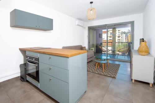 eine Küche mit einer Theke und ein Wohnzimmer in der Unterkunft Studio Port Golfe-Juan Parking Wifi Climatisation Terrasse in Vallauris