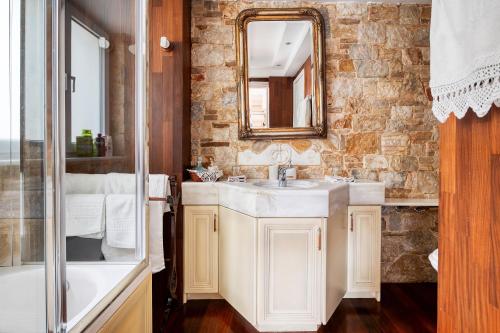 W łazience znajduje się umywalka i lustro. w obiekcie Artistic Villa Luxury w Atenach