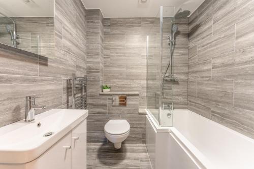 a bathroom with a toilet and a sink and a tub at Luton flat near town centre for Relocators, Tourists, Families in Luton