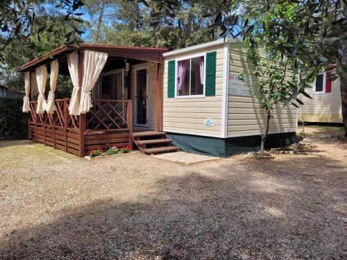 a cabin with awning and a porch at Lucija Mobile Home in Biograd na Moru