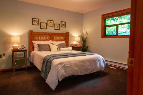 a bedroom with a large bed and a window at The Overlook, Luxury Lakeside Home with Dock in Harrison Hot Springs