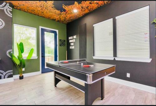 a ping pong table in a room with green walls at CAMP OUT - Big Backyard - 5mins To Downtown in Houston