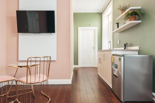 a kitchen with a table and chairs and a refrigerator at Atelier Skalo Boutique Hotel in Willemstad