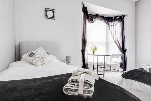 a bedroom with two beds and a table with a chair at City Links-3Bdrm terraced House-Parking-Antonio st in Liverpool