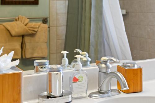 a bathroom sink with soap and a mirror at Studio Boutique Resort Across from Beach in Kihei