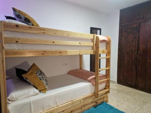 a wooden bunk bed with a ladder in a room at ALCOY-DENIA in Denia