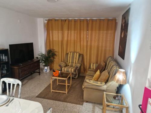 een woonkamer met een bank en stoelen en een televisie bij ALCOY-DENIA in Denia