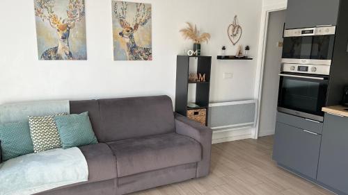 a living room with a couch and a kitchen at Auron Joli appartement in Auron