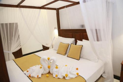1 Schlafzimmer mit 2 Schwänen Handtüchern auf einem Bett in der Unterkunft Natural Lake Down South in Kahanda