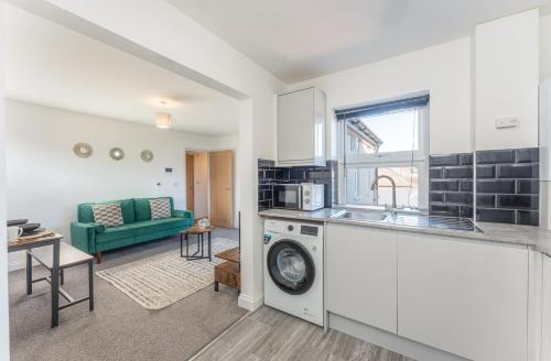 a kitchen and living room with a washing machine at 2 bed Luton town centre flat in Luton