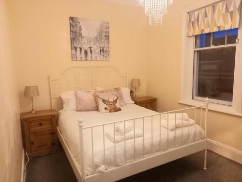 a bedroom with a white bed with a stuffed animal on it at Clock Tower Flats Morpeth in Morpeth