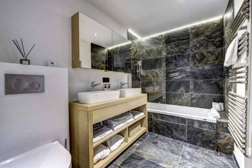 ein Badezimmer mit einem Waschbecken, einer Badewanne und einem WC in der Unterkunft Chalet Green Forest in Chamonix-Mont-Blanc