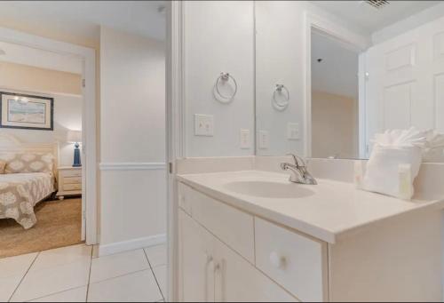 een witte badkamer met een wastafel en een spiegel bij Sterling Shores in Destin