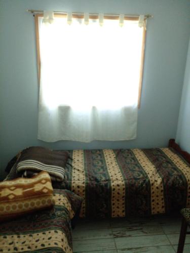 a bedroom with two beds and a window at La Delia in Gualeguaychú