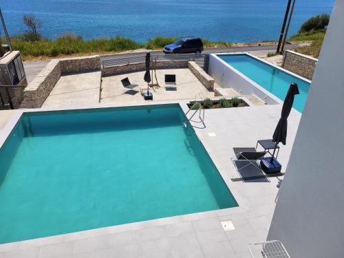 a swimming pool with a view of the ocean at Ionian Sea Villas in Paleros