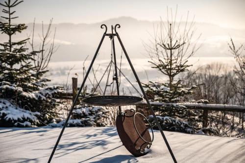 a bag hanging from a swing in the snow at HRYCÓWKA Domki z Widokiem in Grywałd