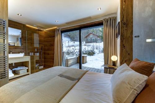 a bedroom with a large bed and a large window at Chalet Green Forest in Chamonix-Mont-Blanc