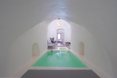 a room with a swimming pool in the middle of a building at Nano Suites in Éxo Goniá