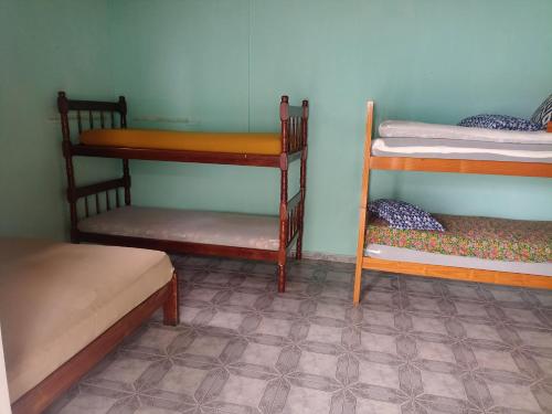 Zimmer mit 3 Etagenbetten und Fliesenboden in der Unterkunft Família Souza in Cabo Frio