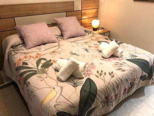 a bed with two pillows and a blanket with flowers at Apartamento en el mismo corazón del Casco Viejo in Bilbao