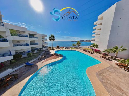 a swimming pool in front of a hotel at Suite Posada frente al mar, Si San Carlos 312 in San Carlos