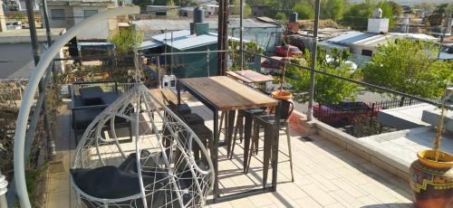 a balcony with a wooden table and a swing at Chalet interno con rooftop in Villa Carlos Paz