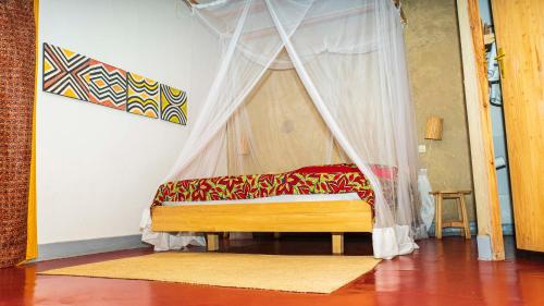 a bed with a canopy in a room at Room in Guest room - Isange Paradise Resort in Ruhengeri